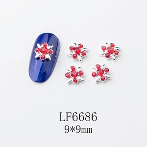 Détail de bijoux d'ongles en forme de fleurs 3D avec strass rouges et base argentée