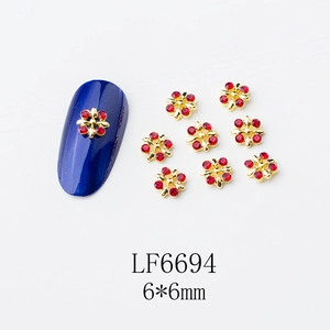 Détail de breloques ongles fleurs dorées 6x6mm avec strass rouges et dimensions