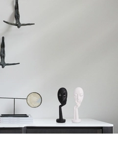 Close-up of modern abstract face sculpture set in black and white matte finish