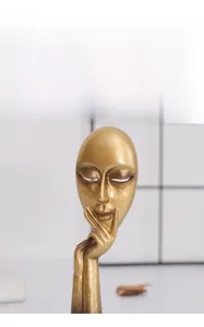 Detail of creative abstract face sculpture with golden matte finish for home decor