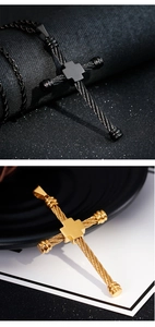 Macro detail of gold and black twisted hip hop cross pendants on textured surfaces