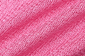 Macro shot of breathable bright pink knitted mesh fabric with detailed honeycomb structure