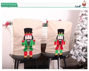 Detail of Christmas nutcracker chair covers in linen fabric with festive red and green colors