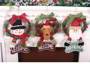 Three Christmas wreaths with Santa, reindeer and snowman hanging on a white fireplace