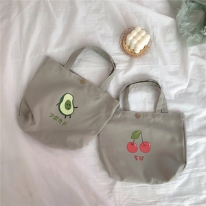 Detailansicht der Canvas-Einkaufstaschen mit Avocado-Druck und metallischem Druckknopfverschluss