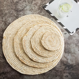 Dettaglio di quattro sottopentola circolari in fibra naturale di mais in varie dimensioni