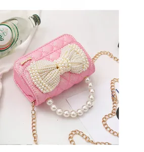Detailed view of pink glitter quilted mini bag with pearl bow and handle accessories