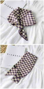 Detail showing purple checkerboard knit scarf texture and small tie-knot styling