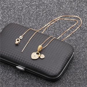 Collier cœur en or avec zircons et ailes d'ange présenté sur un écrin noir luxueux
