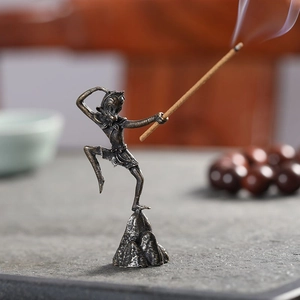Detailed close-up of bronze Monkey King incense burner on zen stone base with wood beads