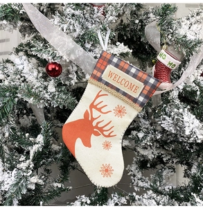 Close-up of small linen Christmas stocking with reindeer print and WELCOME patch