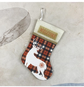 Close-up of red plaid Christmas stocking with reindeer motif and Welcome embroidery