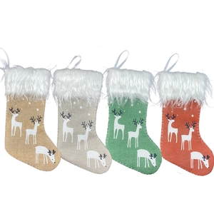 Set of 4 rustic burlap Christmas stockings with white reindeer prints and plush cuffs