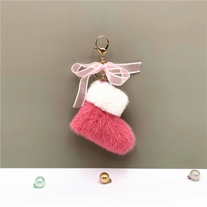 Detail of pink plush Christmas boot keychain with organza bow and golden clasp hardware