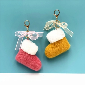 Cute plush Christmas boot keychains with ribbon bows in pink and yellow colors