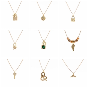 Macro view of gold pendants featuring rhinestones in lock, star, moon, and snake shapes