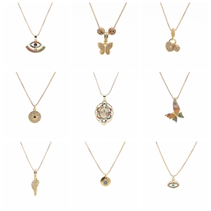 Collage of nine gold pendant necklaces with zircon butterfly, heart, and evil eye designs