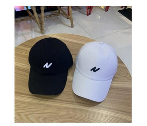 Vue de dessus des casquettes de baseball noir et blanc avec broderie N sur bois