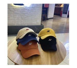 Détail de cinq casquettes de baseball avec lettre N sur une table en bois massif