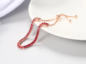 Detail of red square-cut crystal tennis bracelet with adjustable gold-plated chain