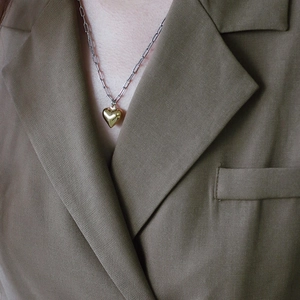 Two-tone heart pendant necklace in gold and silver steel on a female model