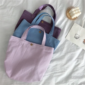 Close-up of three corduroy tote bags in Morandi colors with magnetic metal snap buttons