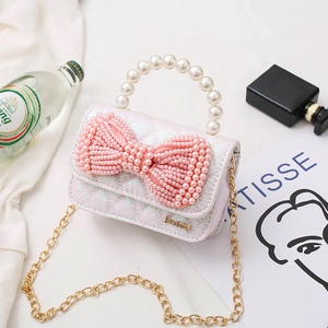 Pink iridescent mini crossbody bag with pearl handle and large bow detail for girls