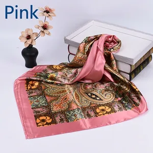Detail of pink silk scarf with vintage paisley patterns and floral print on white base