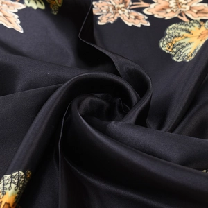 Close-up of black satin silk scarf featuring classic vintage paisley floral patterns