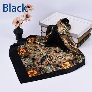 Detail of a black square silk scarf featuring a vintage paisley pattern on a white backdrop