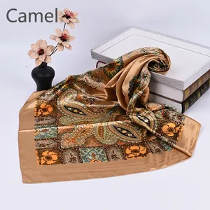 Detailed view of camel paisley silk scarf with vintage geometric prints on white background