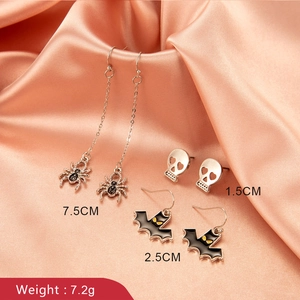 Halloween earring set featuring spider dangles, skull studs, and black bats on satin
