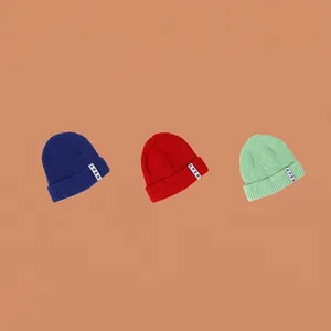 Tre berretti in maglia a tinta unita in blu scuro, rosso e verde menta con etichette APER