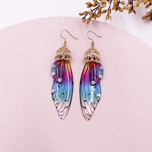 Macro detail of gradient cicada wing earrings with colorful rhinestones and gold floral lace