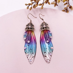 Detailed macro shot of gradient resin butterfly wing earrings with sparkling crystals