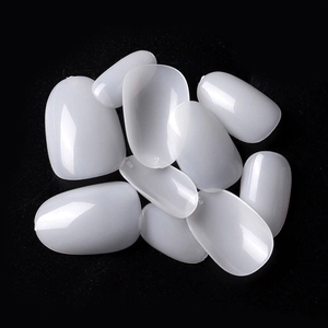 Macro detail of translucent round nail tips with molded size numbers on black background