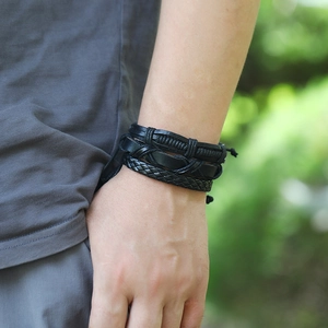 Detail shot of men's multi-layer black braided leather bracelet on a wrist