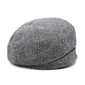 Classic black and white houndstooth newsboy cap for women in a clean flat lay view