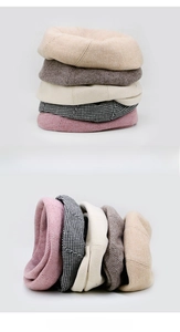 Close-up of five colorful knitted plaid berets in pink, beige, and houndstooth patterns