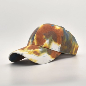Detail of multi-color tie-dye baseball cap featuring blue, brown, and yellow cotton fabric
