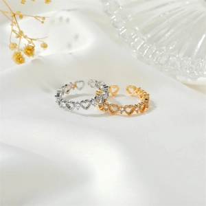Hollow heart open rings in gold and silver with cubic zirconia on silk background