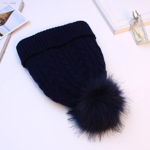Thick navy blue cable knit beanie with large fur pom pom and warm fleece lining