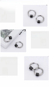 Détail d'une boucle d'oreille en acier 316L argenté avec pendentif cube noir poli miroir