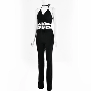 Detail of black halter neck top and high-waist pants on a white mannequin