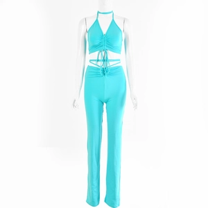 Detailed close-up of teal two-piece set featuring pleated halter top and stretch trousers