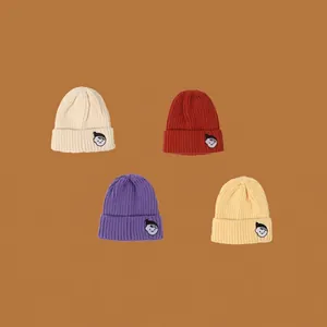 Set of four colorful knit beanies for kids in cream, burgundy, purple, and yellow