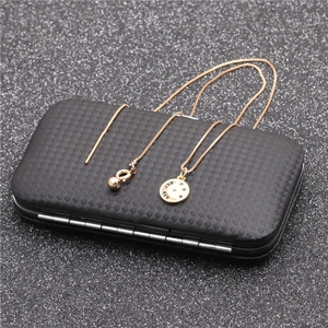 Detail shot of a gold star and moon necklace with zircon stones on a gift box background