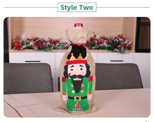 Detail of burlap Christmas wine bottle cover with nutcracker soldier embroidery for tables