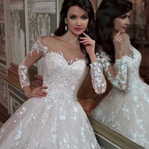 Elegante witte trouwjurk met lange mouwen van kant en een prachtige lange sleep
