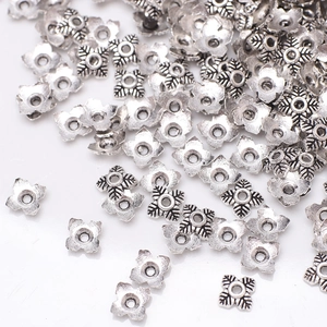 Macro shot of silver flower bead caps with engraved patterns for DIY jewelry making